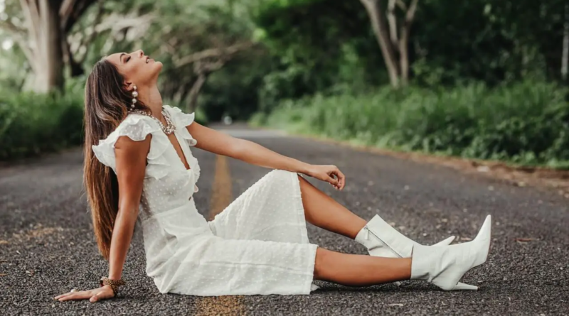 a girl in white dress modelling on the road