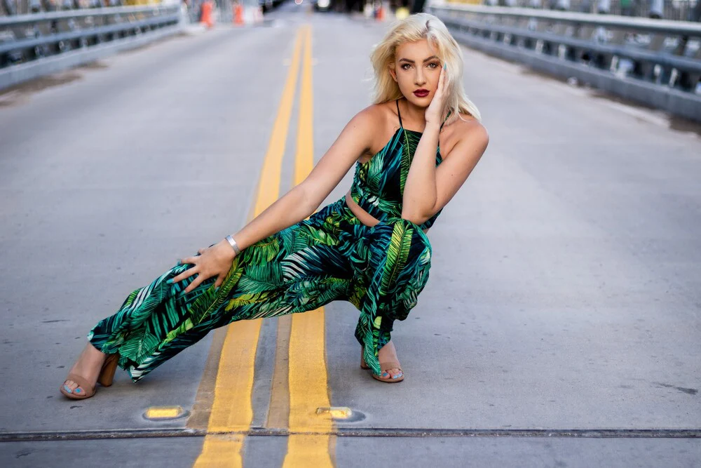 a girl in green dress modelling on the road